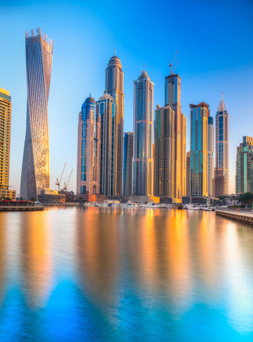 Dubai Marina Blick vom Wasser aus auf die Skyline, das Wasser spiegelt die Hochhäuser im stillen Wasser.